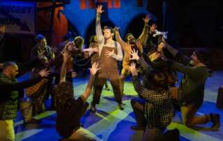 actors on stage in a musical