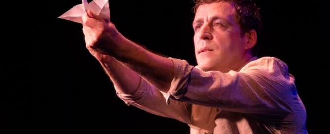 actor on stage with paper bird