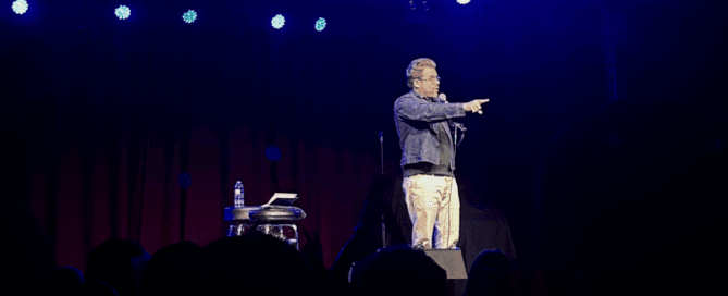 comedian Adam Conover on stage in Denver