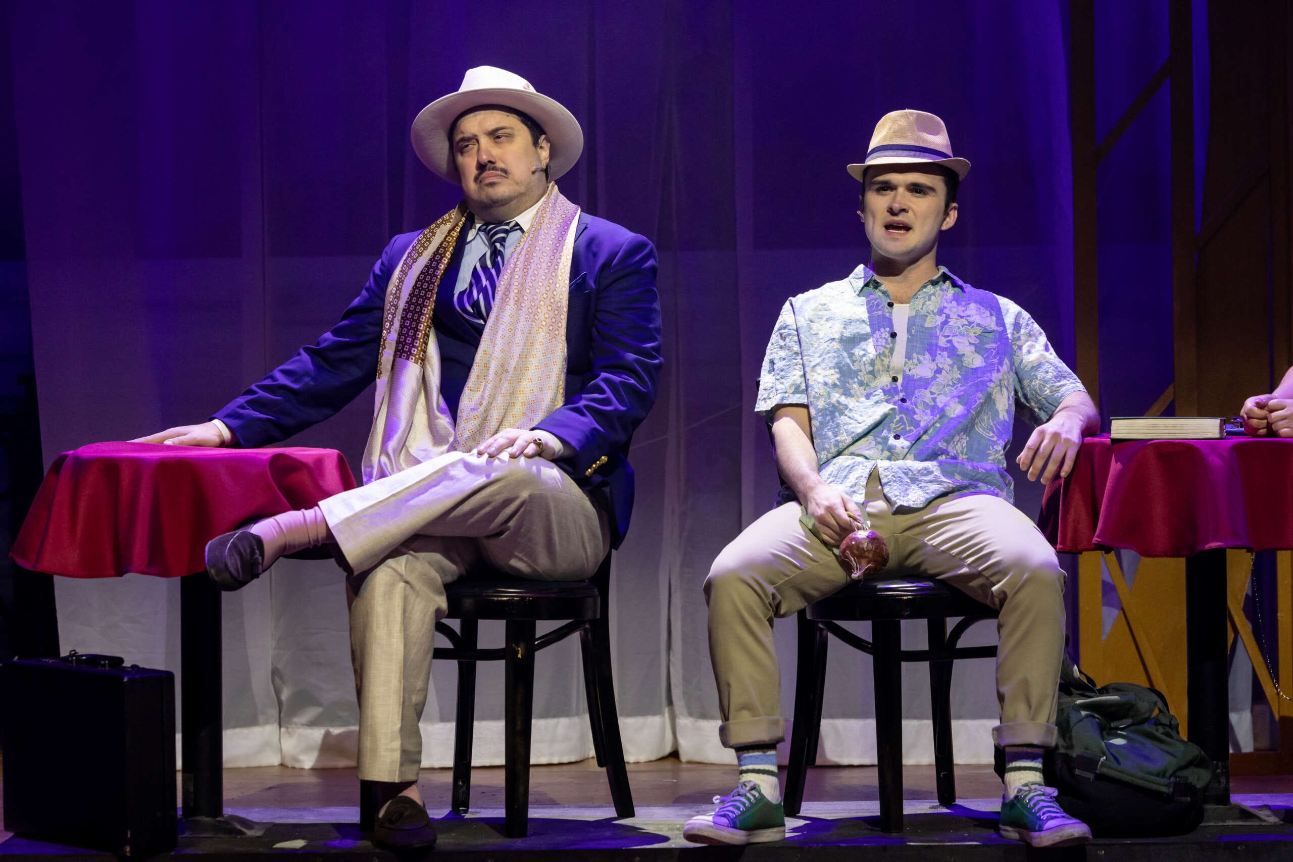 Two actors sit next to each other onstage