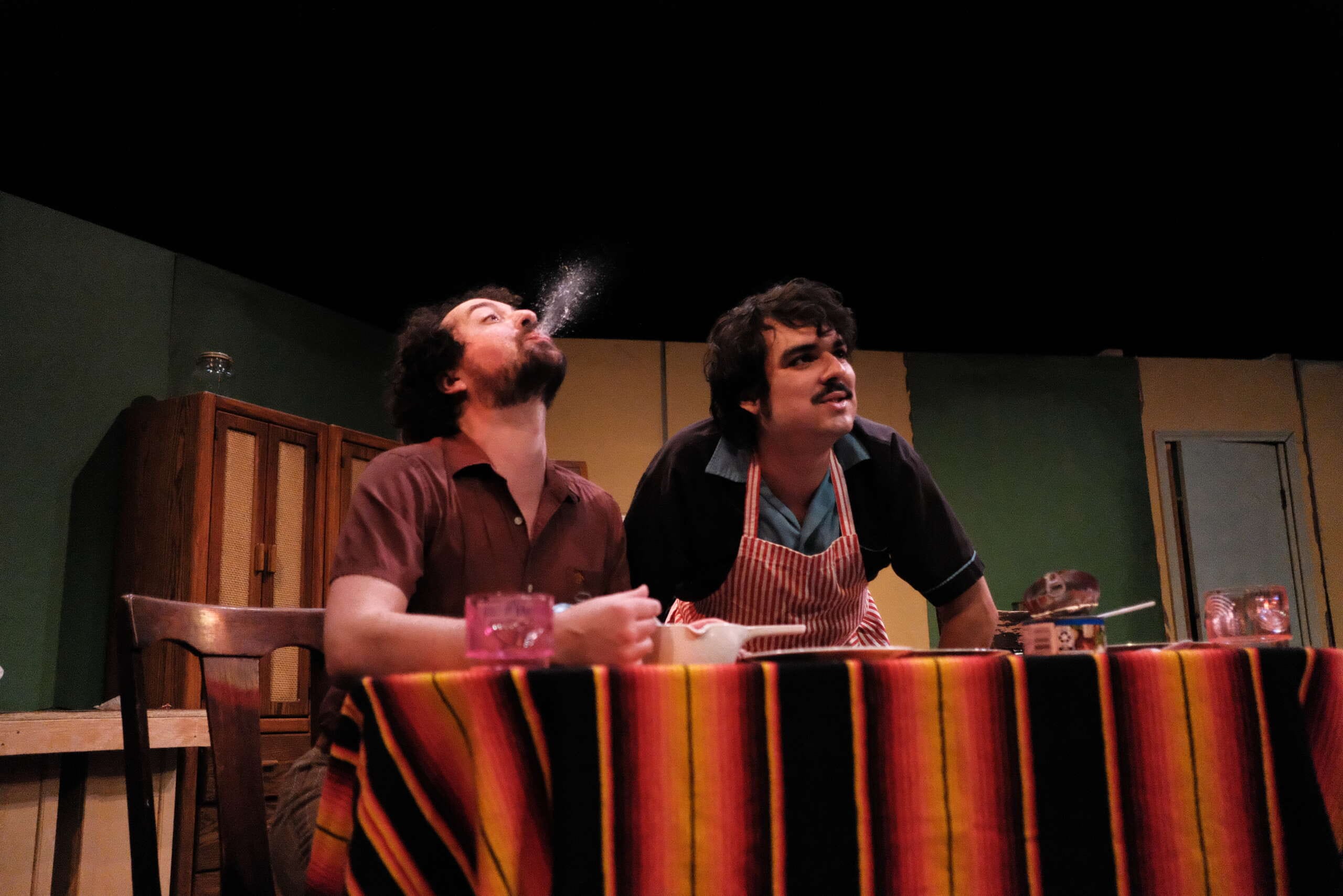 A man does a spit take next to another guy