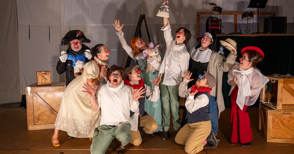 A troupe of actors pose together