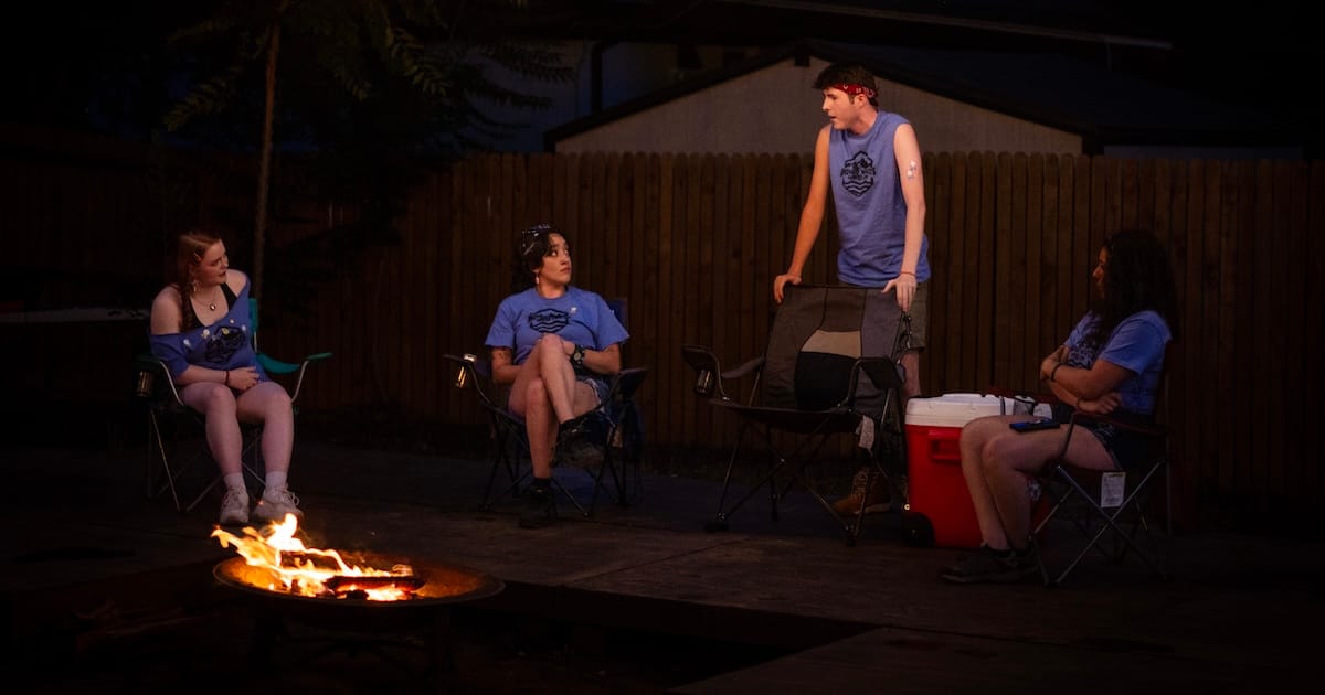 People gather around a campfire in The Grown-Ups