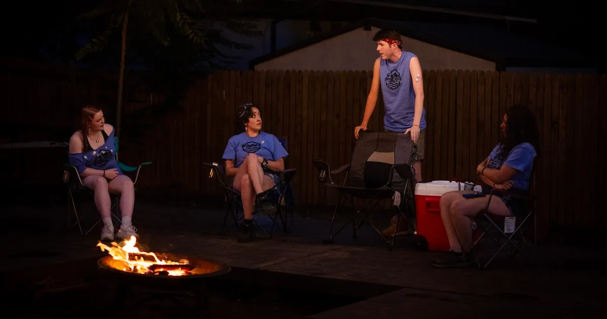 People gather around a campfire in The Grown-Ups