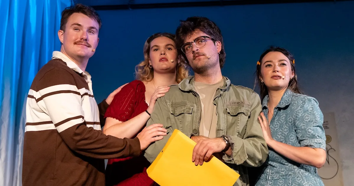 Four actors look dramatically out at the audience