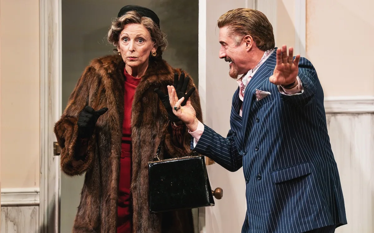 A man greets a disgruntled woman in a scene from "Barefoot in the Park"