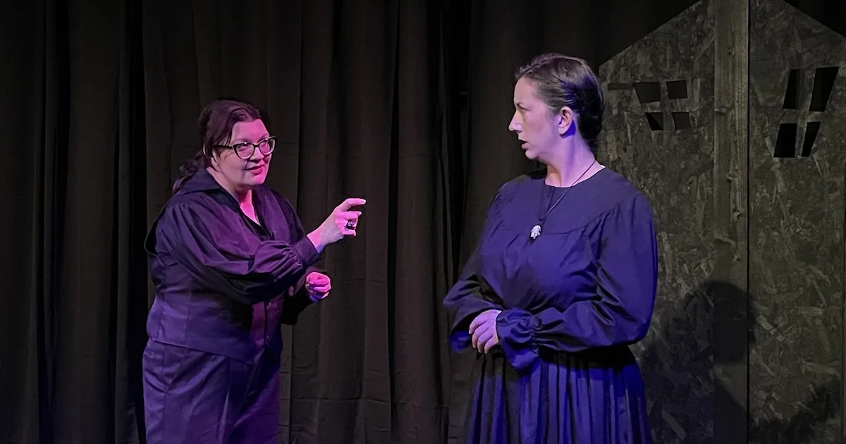 A woman speaks to another in a local production of "The Turn of the Screw"