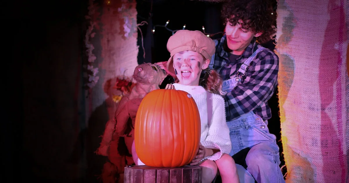 A little girl with a cat puppet and a pumpkin in "The Pumpkin Kid"