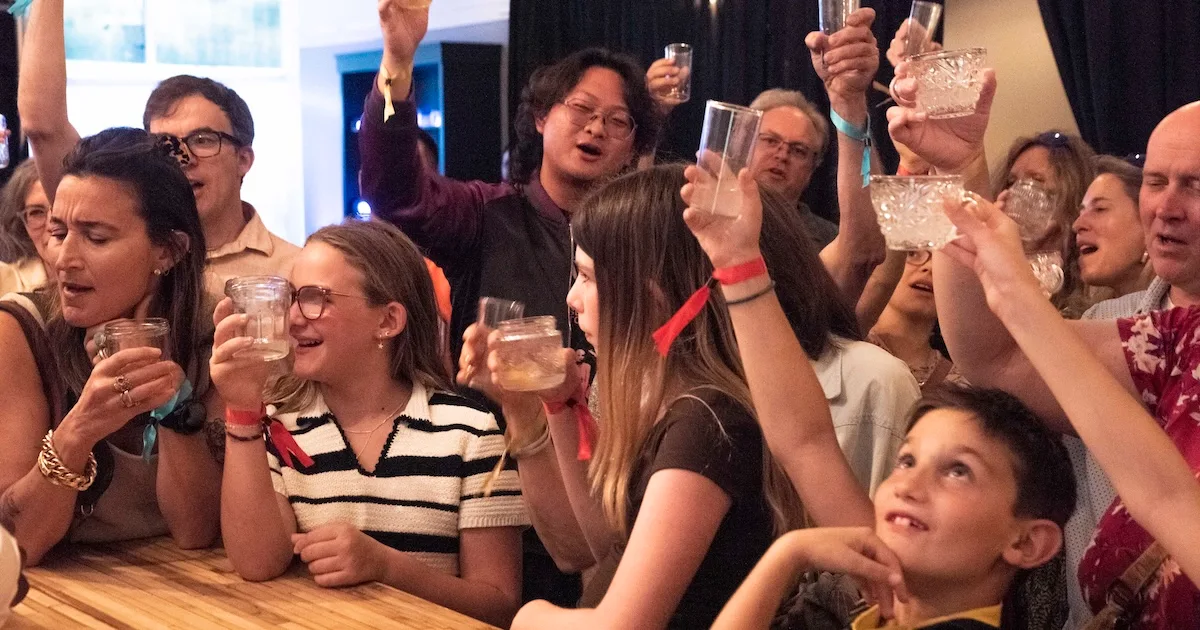 People raise a glass together in "SIP"